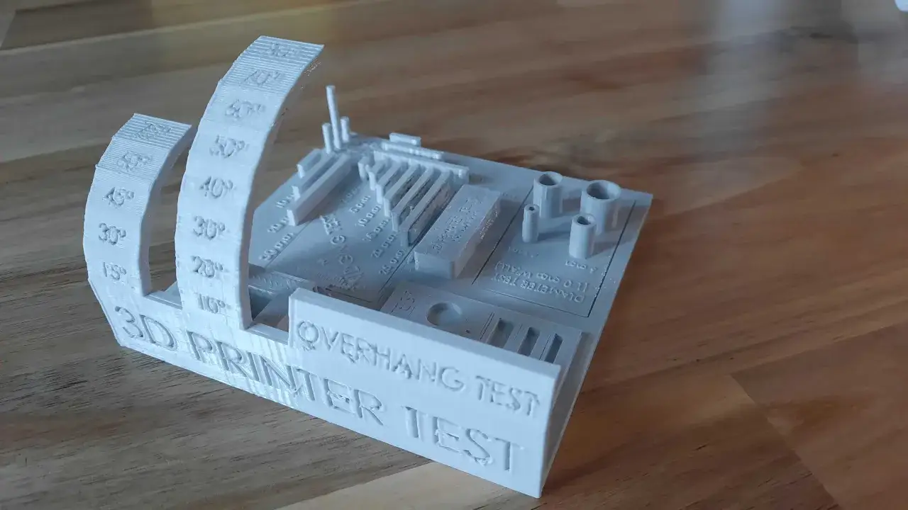 Biały model 3D do testu drukarki, z oznaczeniami kątów, mostków i średnic.