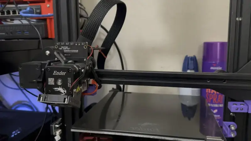 Głowica drukująca klipper ender 3 z kablem w oplocie. Na półce w tle fioletowa puszka z napisem "aussie".
